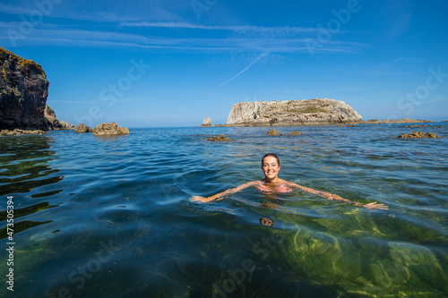 Happy woman swimming in the sea of an idyllic beach
