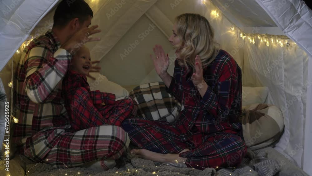 Parents tell their child a story before bedtime. Happy family at home on the eve of Christmas