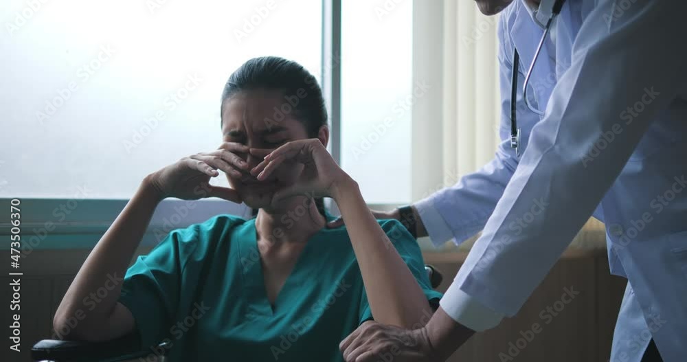 At the hospital, an overworked young woman in a wheelchair closes her eyes and sobs. The doctor reassured her and spoke with her to see if she needed any help.