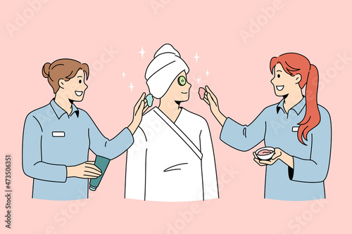 Beauty spa and cosmetology concept. Smiling women dermatologists wellness workers standing taking care of female client skin making beauty treatments vector illustration 