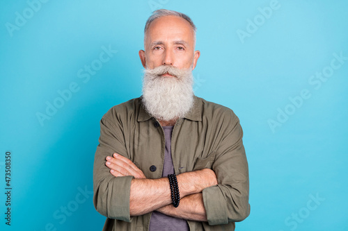 Portrait of attractive content grey-haired man folded arms isolated over vibrant blue color background © deagreez