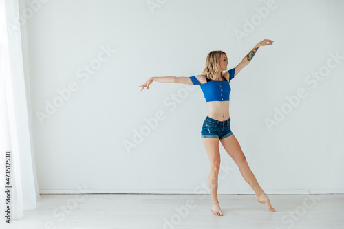 beautiful athletic blonde woman dancing to music alone