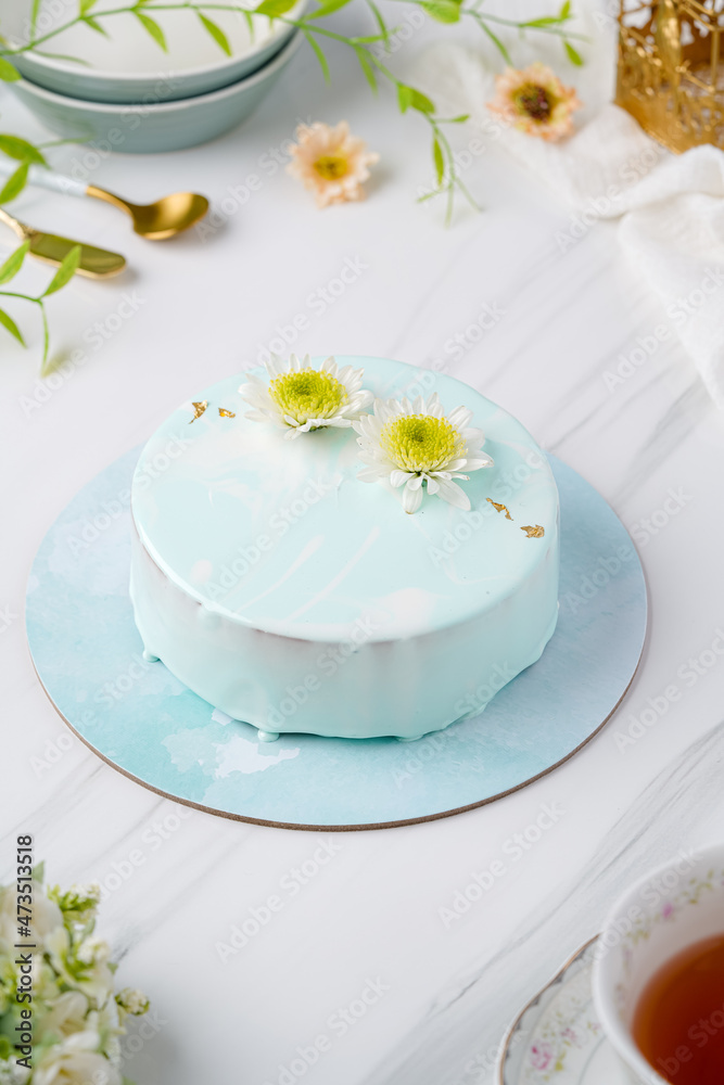 Trendy mousse cake with mirror glaze decorated. Modern european desserts at white marmer stone background.