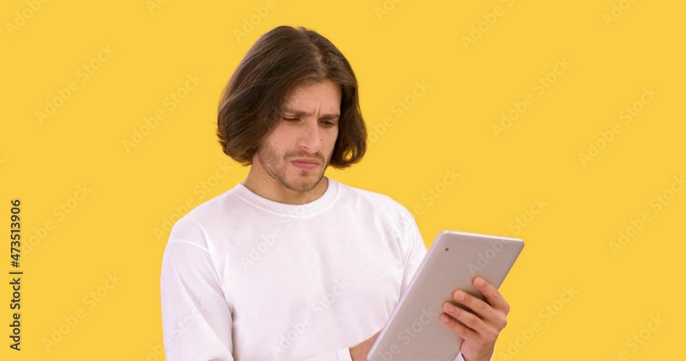 Awful internet news. Young man web surfing on digital tablet, watching disgusting content and scrolling web page Awful internet news. Young man web surfing on digital tablet, watching disgusting content and scrolling web page