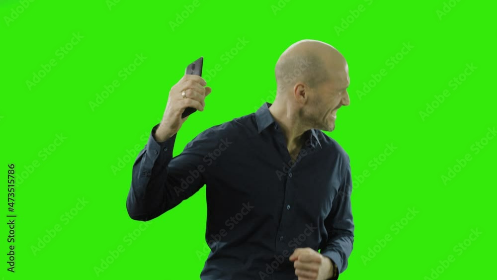 success man in suit is relieved after looking on his phone in front of a greenscreen success man in suit is relieved after looking on his phone in front of a greenscreen