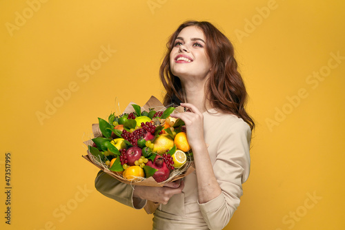 pretty woman fun posing fruit bouquet vitamins yellow background