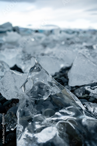 crystal clear Iceberg laying on the beach of Jökulsárlón glacier lake on black sand