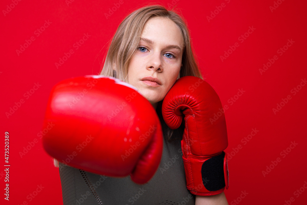Sporty young woman in red boxing gloves practicing punches Sporty young woman in red boxing gloves practicing punches