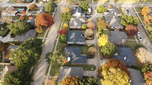 Aerial video of residential neighborhood in suburbs Dallas, Texas with colorful fall foliage. Well established single family house subdivision with bright autumn colors at sunset photo