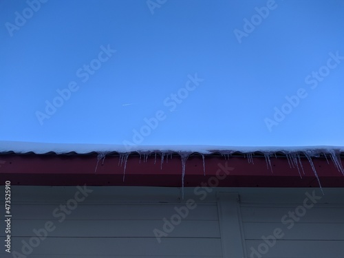 icicles against a blue sky and two flying planes.