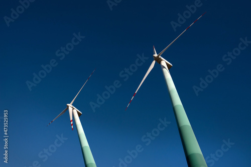 Two wind turbines against the backdrop of the blue sky