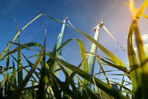 Wind turbine for electricity generation, view from grass with sunshine, ecolo...