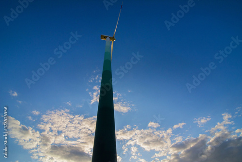 wind turbine closeup on sky with clouds background, bottom up view