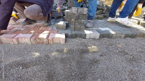  Construction worker laying paving slabs on the street. 