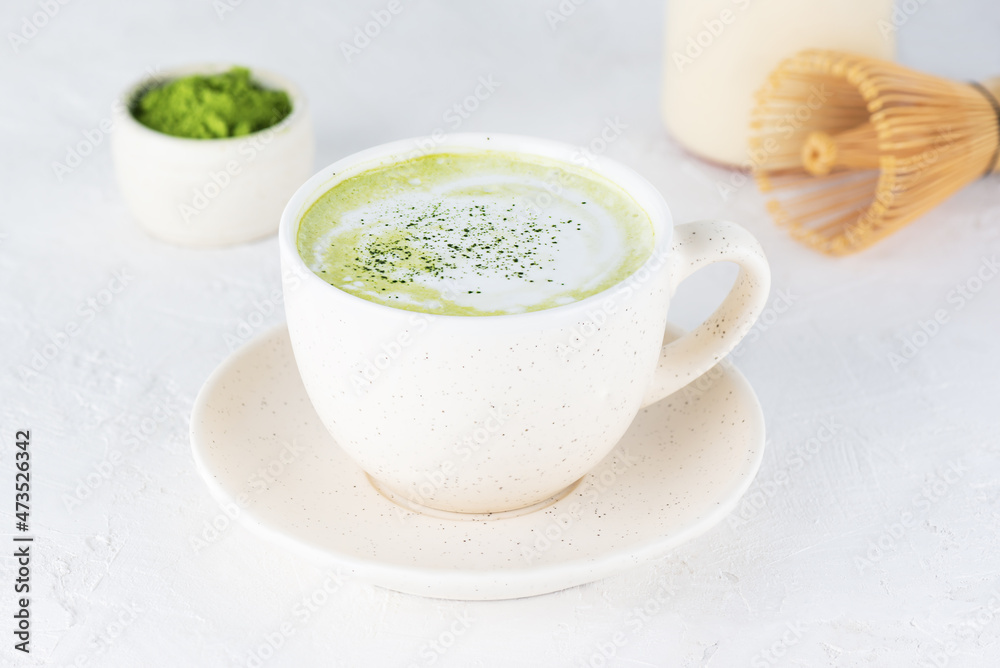 Vegan tea matcha latte with coconut milk and hemp seeds in a mug on a light background. Vegan tea matcha latte with coconut milk and hemp seeds in a mug on a light background.