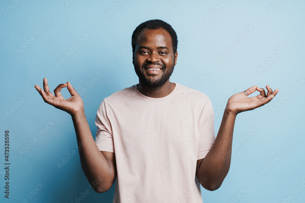 Black bristle man laughing while making zen gesture