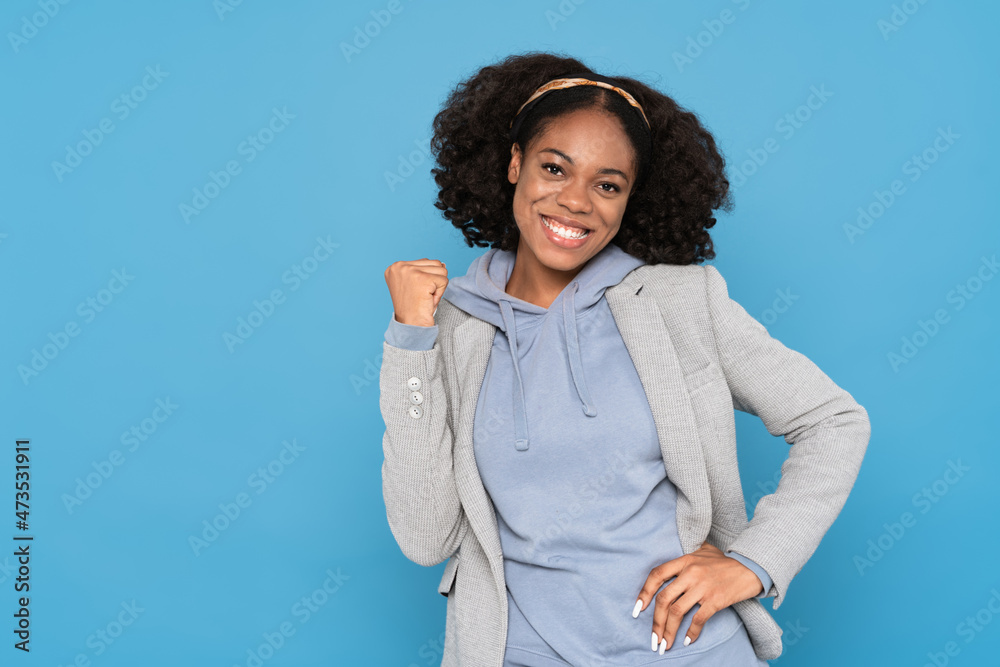 Young black woman wearing jacket smiling while making winner gesture Young black woman wearing jacket smiling while making winner gesture