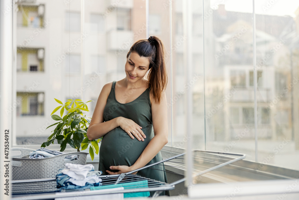 Blessed pregnancy and household chores. A pregnant woman holds her