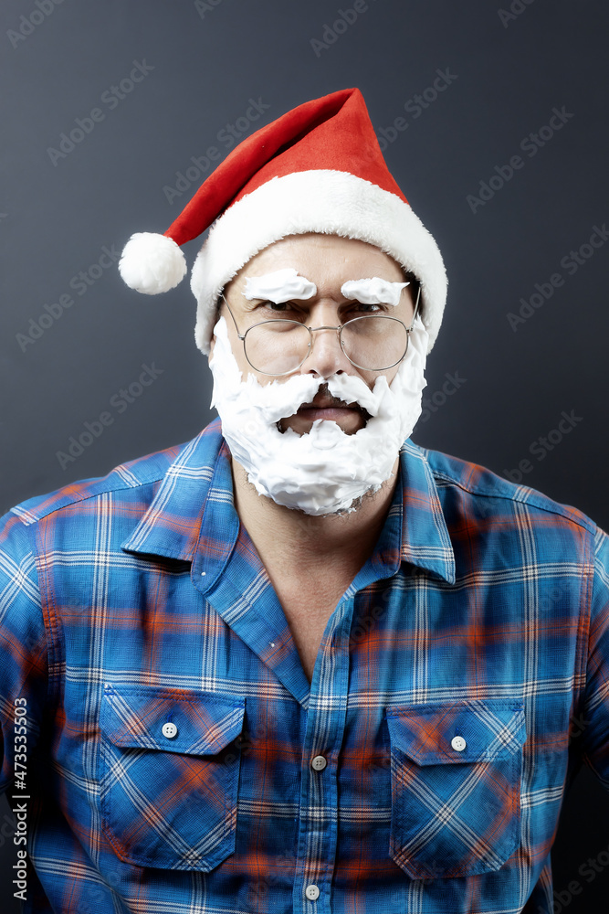 Gloomy disguised Santa with a foam beard. Christmas poster. Disgruntled santa Gloomy disguised Santa with a foam beard. Christmas poster. Disgruntled santa