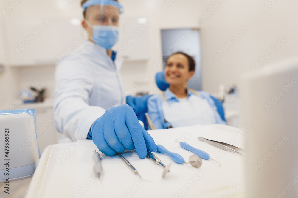 Obraz premium Dentist taking dental tools to provide treatment for client