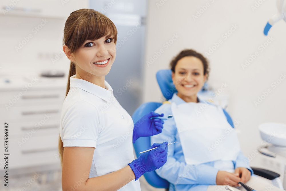 Dentist posing at camera with dental tools in hands Dentist posing at camera with dental tools in hands