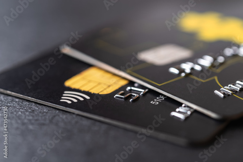 Two black debit cards for cash withdrawals and money transfers. Credit cards with chip and contactless technology macro. Bank charge card for payment for goods and services. photo