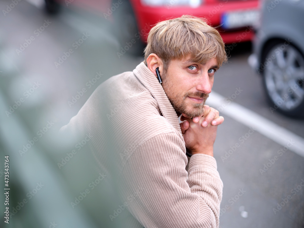 Man with hand on chin sitting by roadside Man with hand on chin sitting by roadside