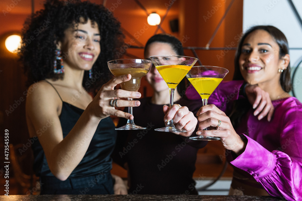Female friends toasting martini glass in restaurant Female friends toasting martini glass in restaurant