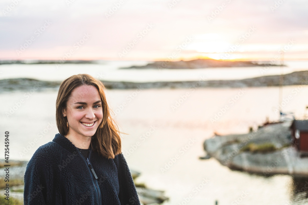 Portrait of smiling woman against sea during vacation