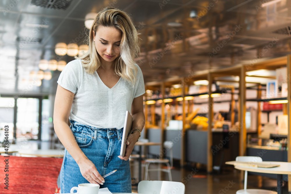 Businesswoman holding digital tablet while standing at coffee shop Businesswoman holding digital tablet while standing at coffee shop