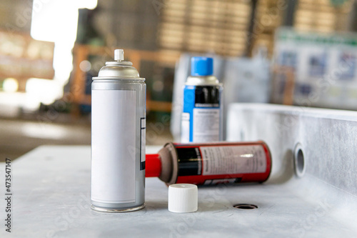 Cans of spray Penetrant Testing on on material steel and blur factory in background photo