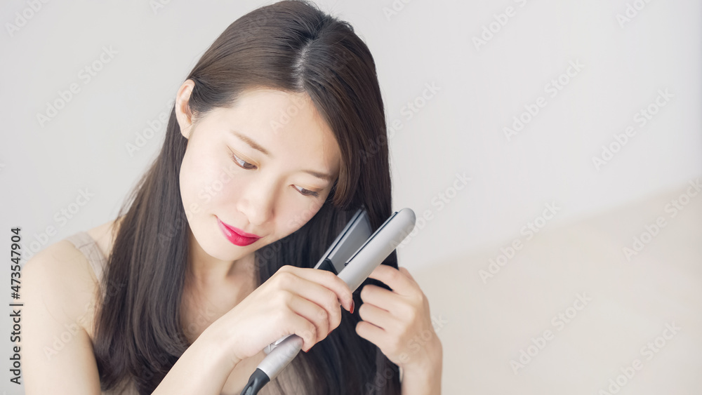 ヘアアイロンを使う女性 スタイリング ヘアアイロンを使う女性 スタイリング