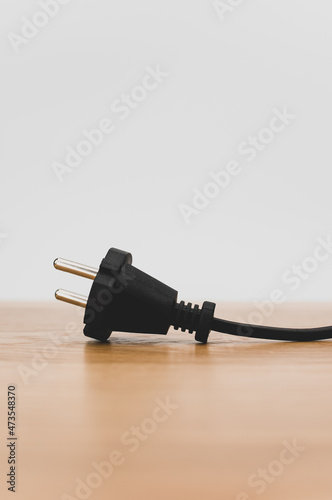 electrical power cord with plug on a wooden worktop