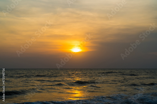 Beautiful golden sunrise over the sea ocean waves. © pornpun