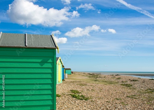 bright green beach huts on the beach at Littlehampton England