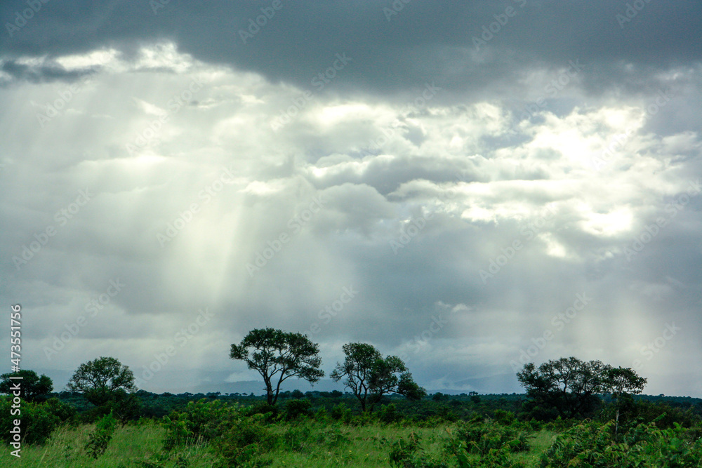 light shining through clouds onto country landscape