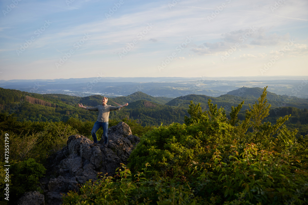 Man with arms outstretched standing on mountain Man with arms outstretched standing on mountain