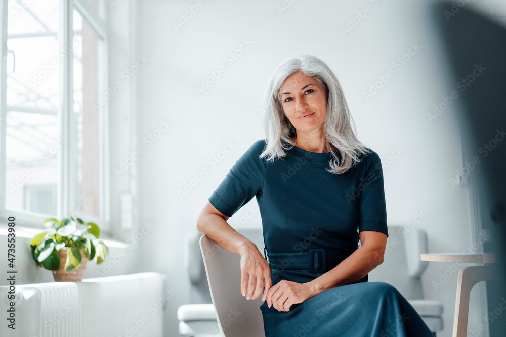 Mature businesswoman sitting on chair at office Mature businesswoman sitting on chair at office