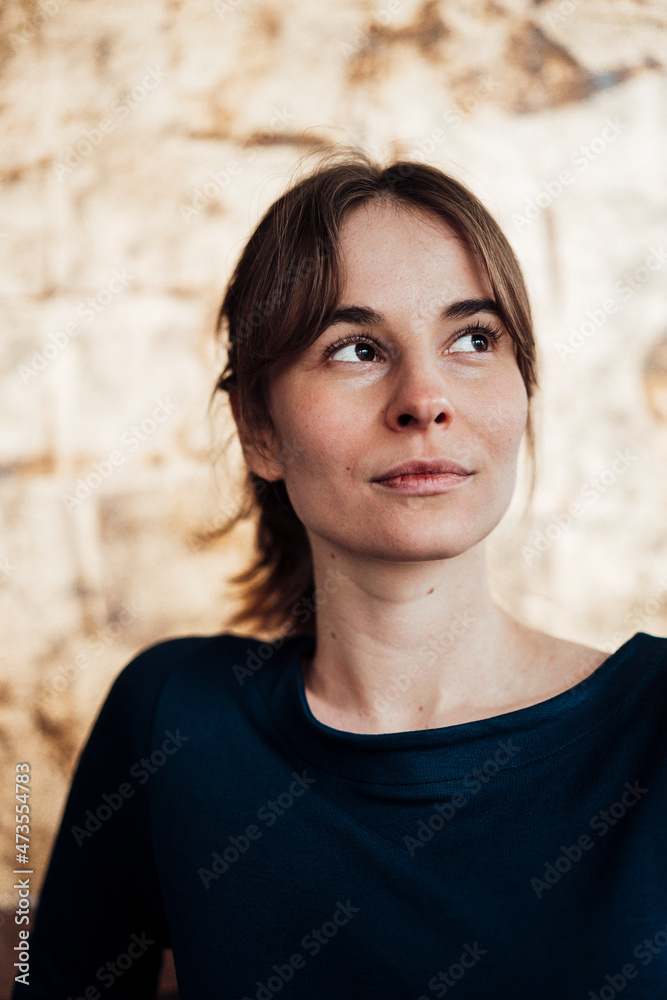 Young woman with brown hair looking away