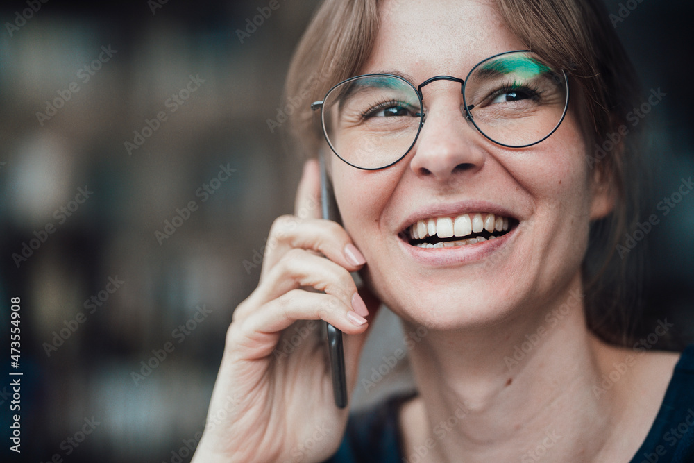 Happy young businesswoman wearing eyeglasses talking on smart phone Happy young businesswoman wearing eyeglasses talking on smart phone