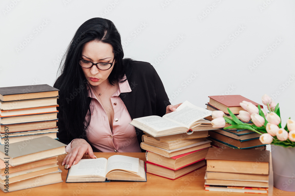 female teacher at a table with books for teaching female teacher at a table with books for teaching