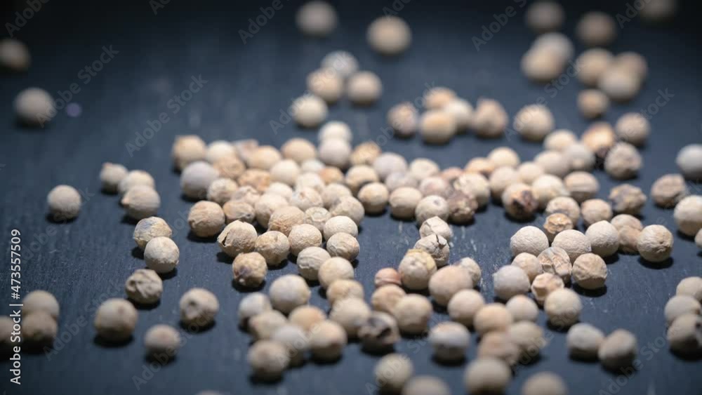 Close-up video of a slowly rotating white pepper on a gray wooden table. Background in blur. Close-up video of a slowly rotating white pepper on a gray wooden table. Background in blur.