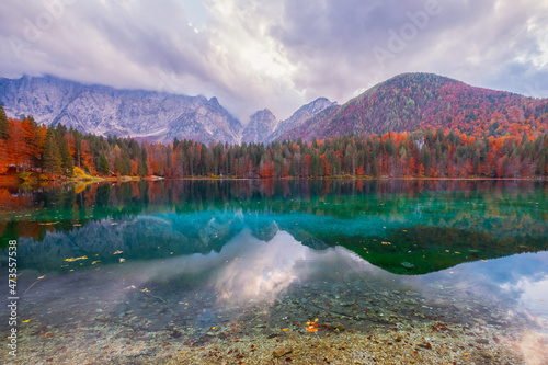 Beautiful Fusine lake in nice autumn colors in the background with the Mangart mountains at sunset, near Slovenia photo