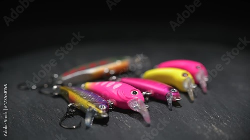 Fishing lures of different colors and shapes for fishing on a brown table. Background in blur.