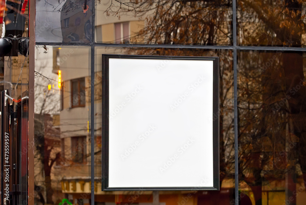 Rectangular sign on the building. Copy space and space for text. Mockup for design. Blank template for advertising. White frame on a glass case. Advertising on the window of a restaurant or shop. Rectangular sign on the building. Copy space and space for text. Mockup for design. Blank template for advertising. White frame on a glass case. Advertising on the window of a restaurant or shop.