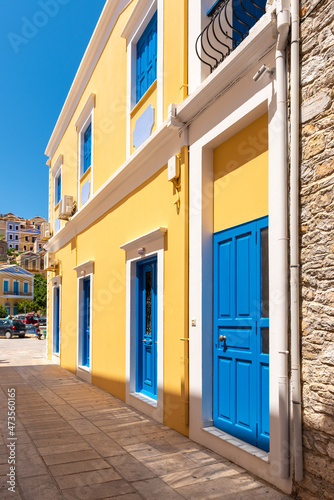 Greek house with blue door and window on Symi island in Greece © vivoo