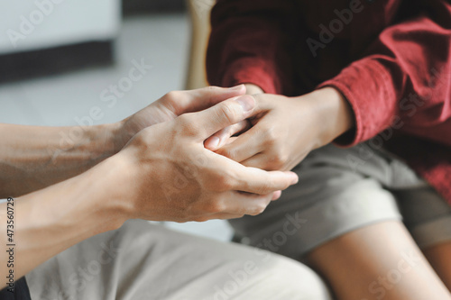 Young couple are holding hands join pray together with the light from above