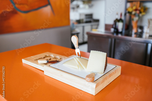Manchego cheese with knives at counter photo