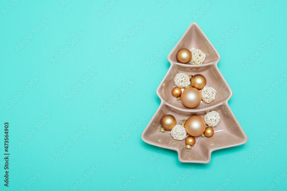Green background with gold balls and porcelain dish. New Year's decoration. Background. Christmas. Spruce.