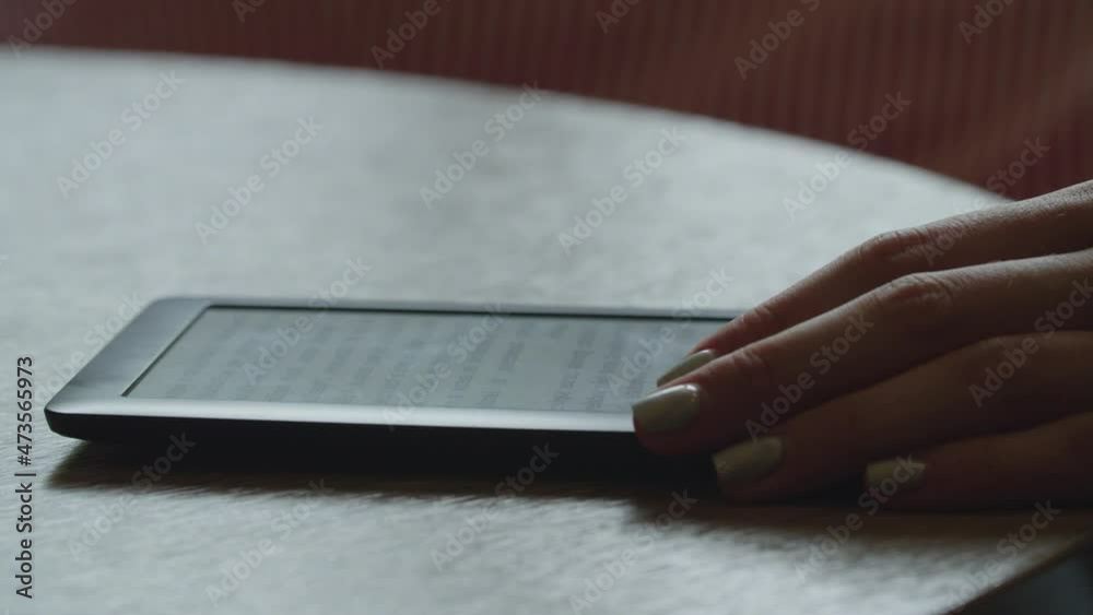 E-book on the table with a woman's hand close-up